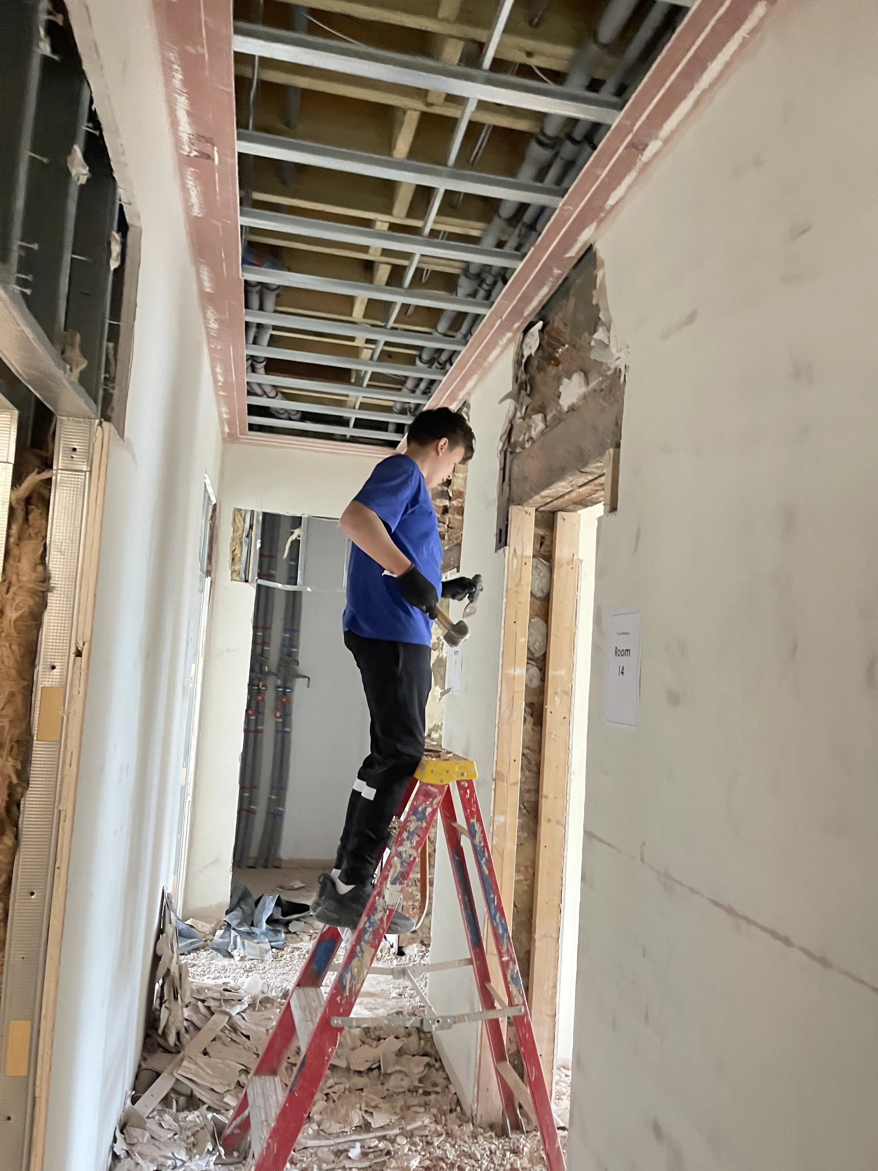 Community Heroes volunteer carrying out skilled work on a ladder